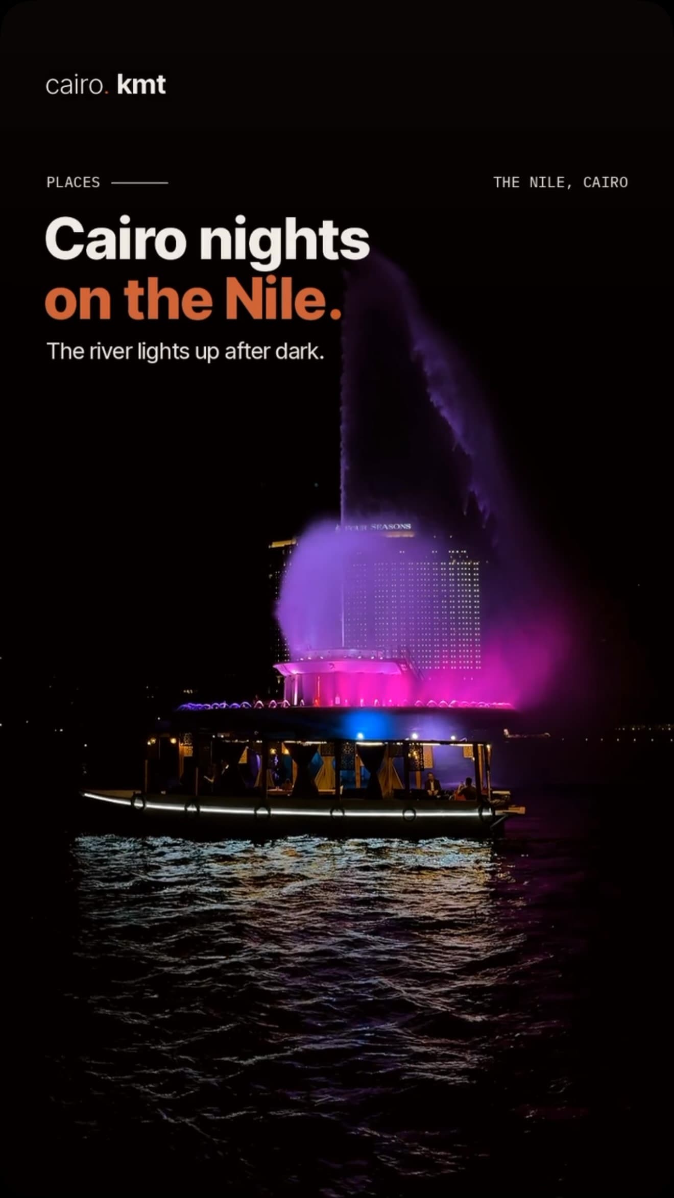 A lit fountain and boat on the Nile at night