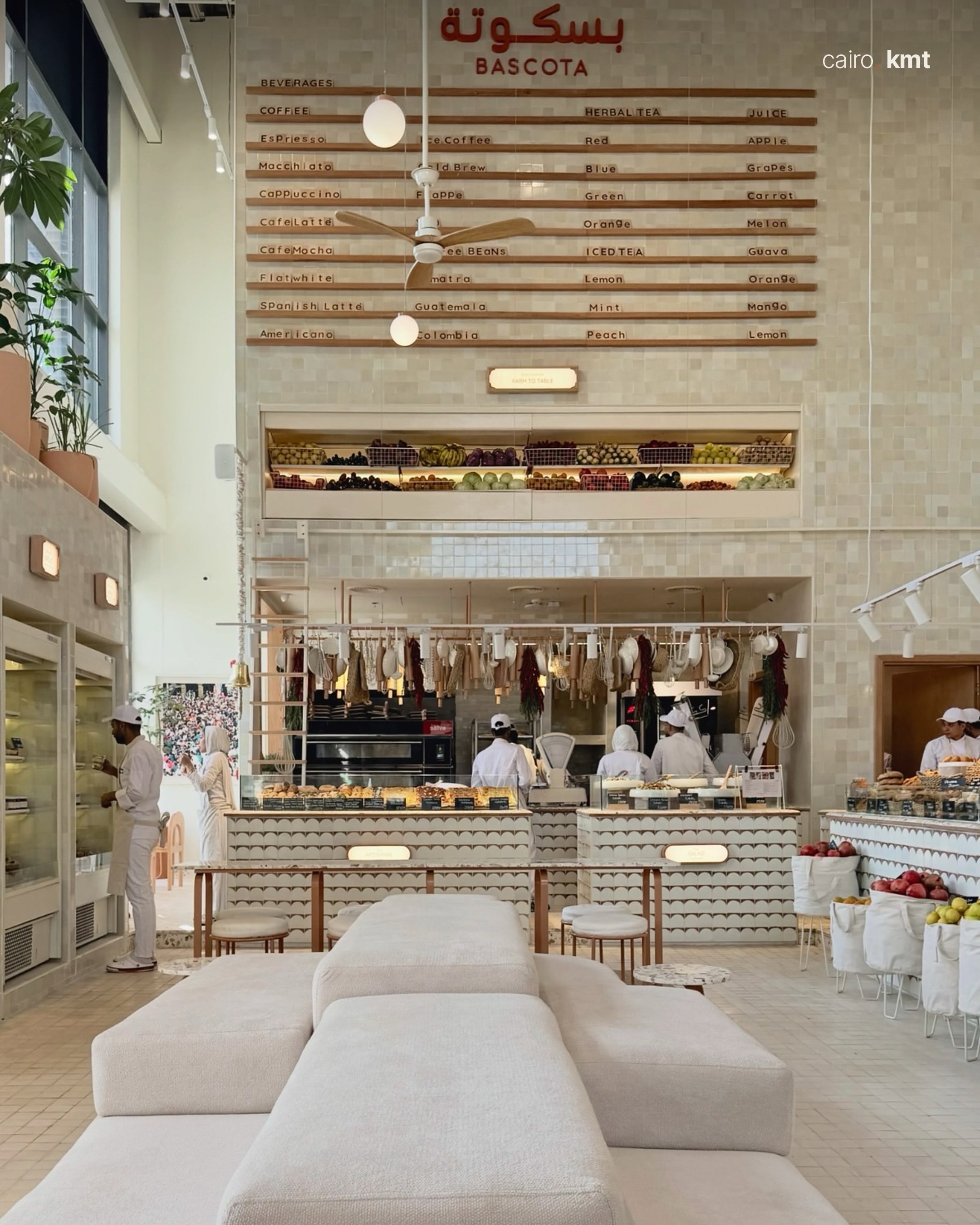 Inside Bascota, a bright bakery café with tall windows and palms