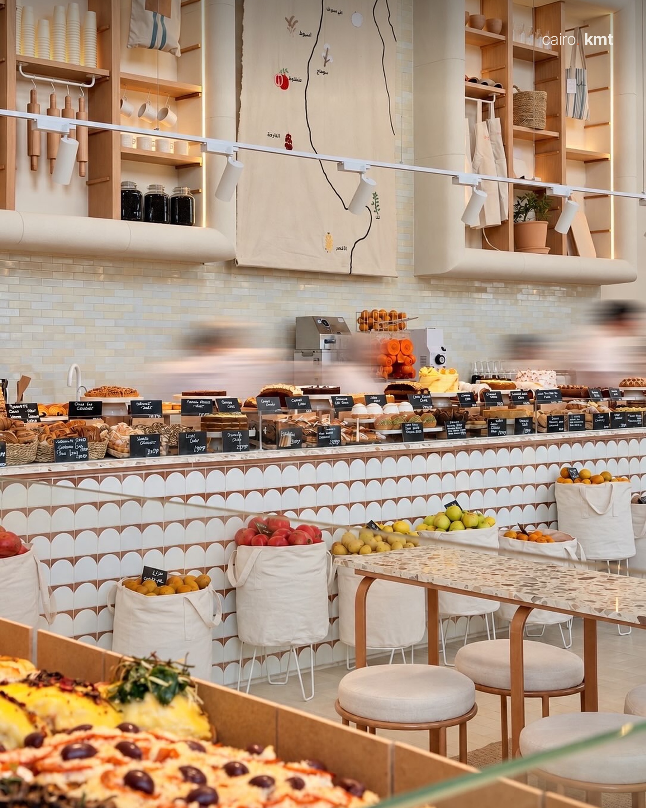 Inside Bascota, a bright bakery café with tall windows and palms
